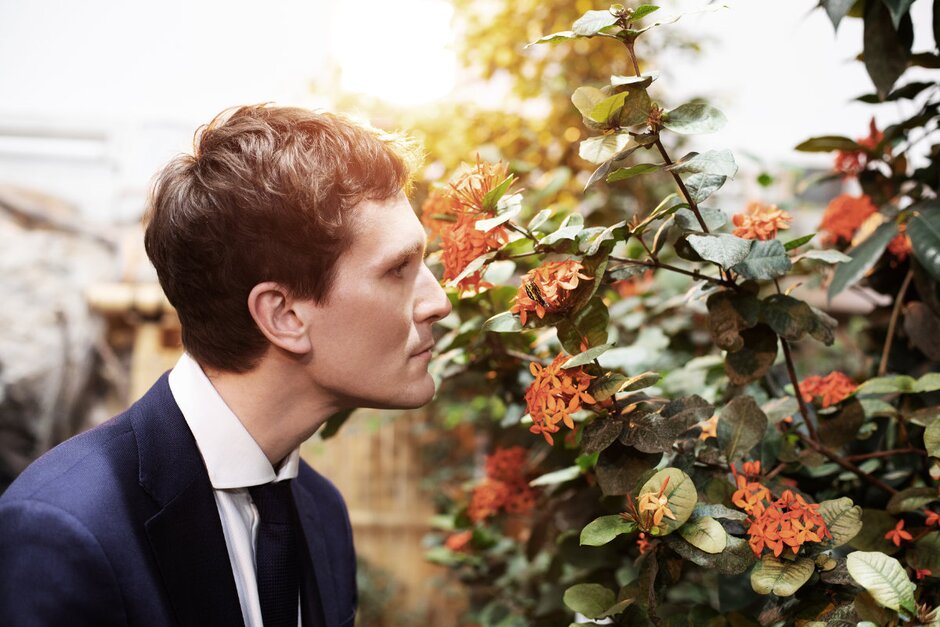 Hosea Ratschiller riecht an einer Blume